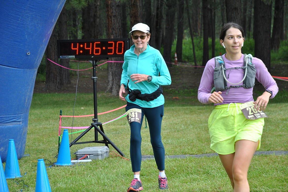 Left, Vicki Morgan, 70, from Stevensville, crosses the finish line at the St. Regis Park on June 17, with a time of 1:41:04. Just in front of her, in the purple long sleeve is the female first place finisher for the 30K run, Whitney Young from Silverton, Idaho. She finished with a time of 2:46:09 on Saturday morning. (Mineral Independent/Amy Quinlivan)