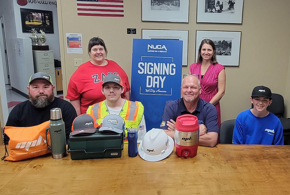 Dillion Plaster, who recently graduated from Sandpoint High School, signed on to join the team at NPL Construction and received a $500 National Utility Contractors Association "signing bonus" prize to be used for job site rain gear and work boots. Pictured in the front row, from left are are Plaster’s father Mark Plaster, Dillon Plaster, Rick Oliver, and Plaster’s younger brother, Peyton. Pictured in the back row are Jeralyn Mire, SHS post secondary counselor, and counselor Tavi Brandenburg.