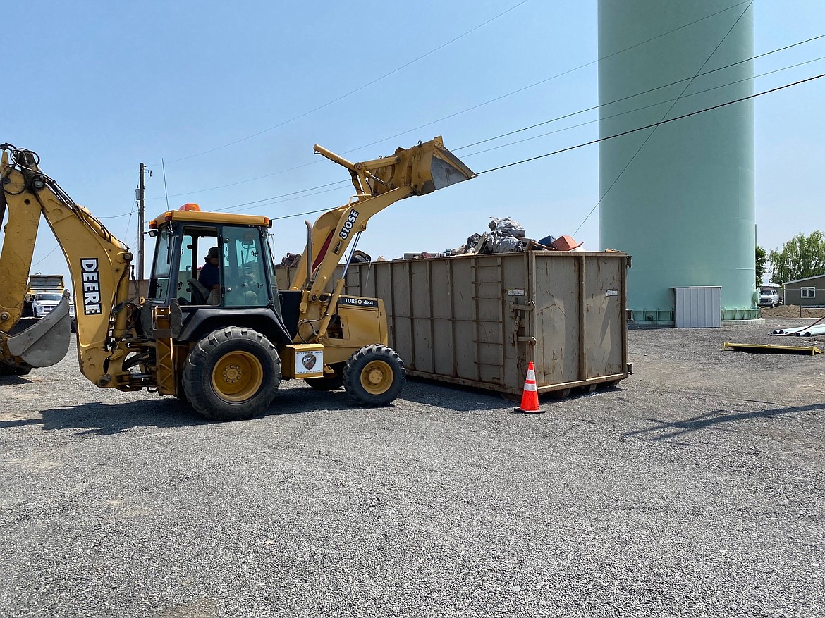 Crews dump rubbish into a garbage container during the spring cleanup in May. The cleanup was successful enough that city officials are considering a second one in the fall.