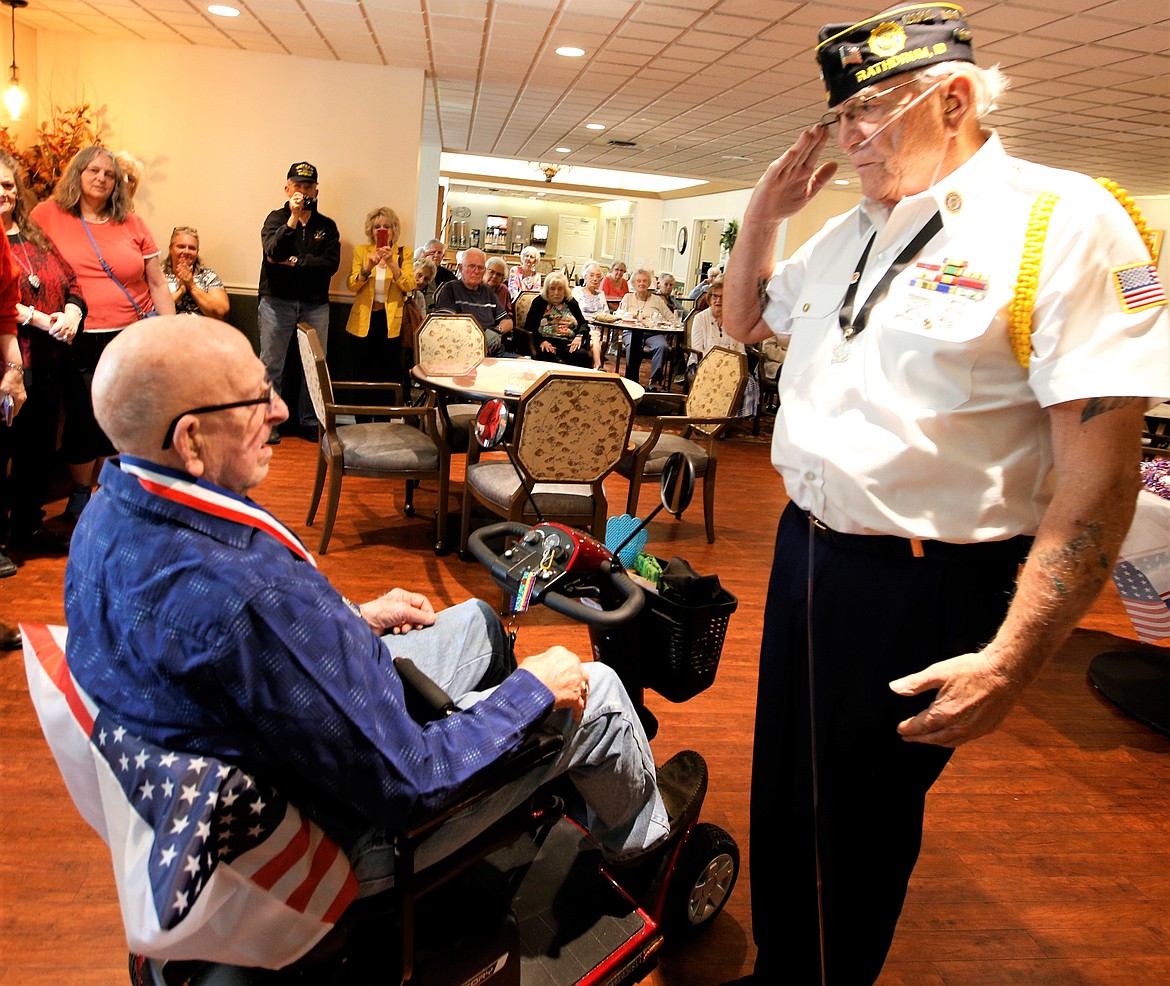 Lew Allert salutes Robert Lawless after presenting a medallion on Sunday.