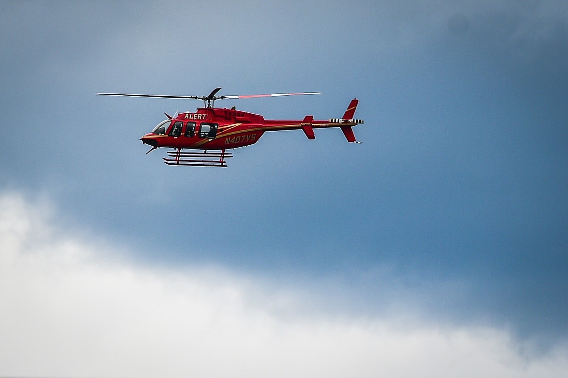 The A.L.E.R.T. rescue helicopter escorts the tractor-trailer carrying The Wall That Heals through downtown Kalispell on Tuesday, June 20. (Casey Kreider/Daily Inter Lake)