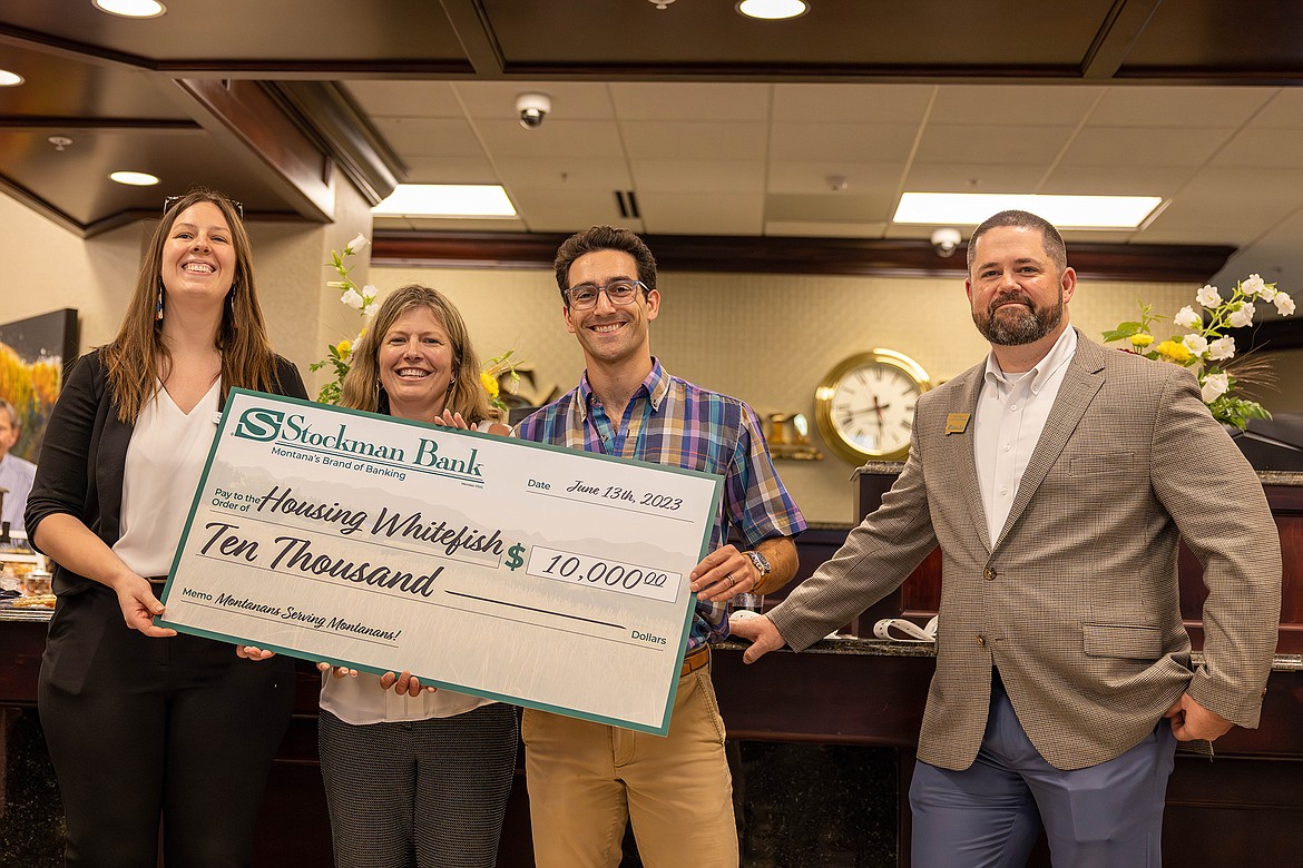 Representatives from Housing Whitefish accept a donation of $10,000 from Stockman Bank at its Whitefish branch grand opening celebration. (Provided photo)