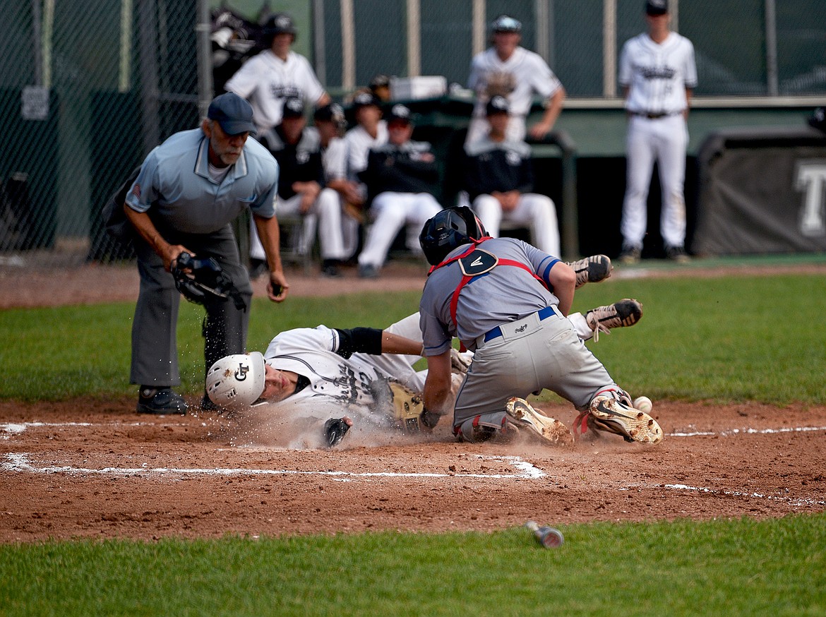 Glacier Twins' Mikey Glass slides across home plate to score against Libby on Thursday in Whitefish. (Whitney England/Whitefish Pilot)