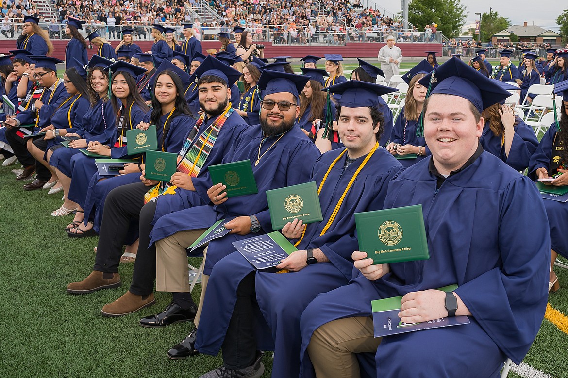 Members of the class of 2023 pose with their diplomas after receiving their degrees Friday evening at Lions Field in downtown Moses Lake.