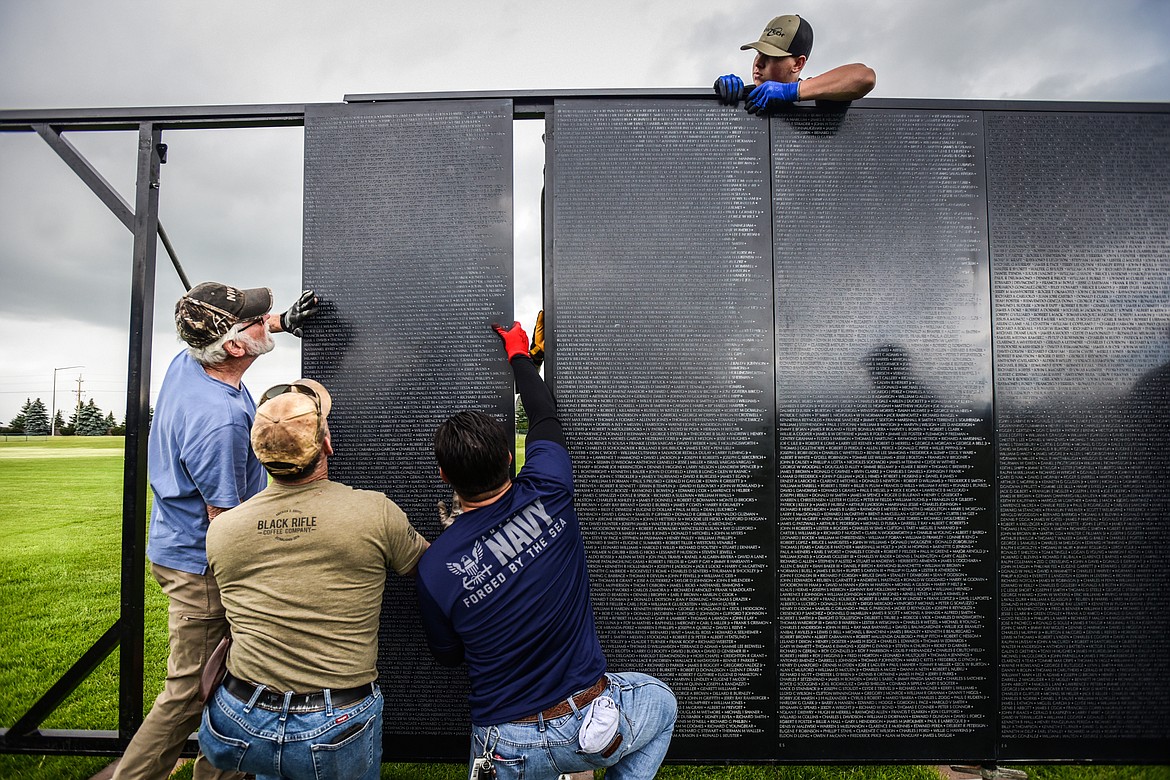Crews of veterans and volunteers carry individual panels and manuever them into place at The Wall That Heals at the Glacier High School soccer fields on Wednesday, June 21. The Wall That Heals is a three-quarter scale replica of the Vietnam Veterans Memorial in Washington D.C. (Casey Kreider/Daily Inter Lake)