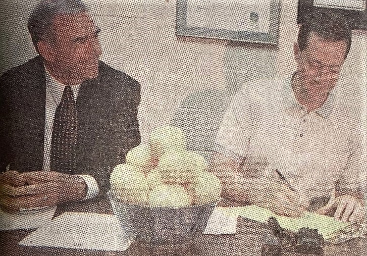 Mayor Steve Judy signs Lemons to Lemonade pledge while Doug Cresswell, president of the Kootenai County Task Force on Human Relations, watches.