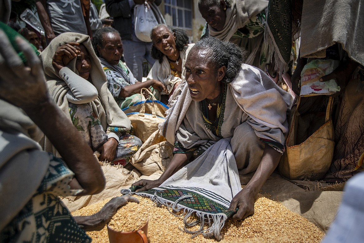 An Ethiopian woman argues with others over the allocation of yellow split peas after it was distributed by the Relief Society of Tigray in the town of Agula, in the Tigray region of northern Ethiopia, on May 8, 2021. In 2023 urgently needed grain and oil have disappeared again for millions caught in a standoff between Ethiopia's government, the United States and United Nations over what U.S. officials say may be the biggest theft of food aid on record. (AP Photo/Ben Curtis, File)