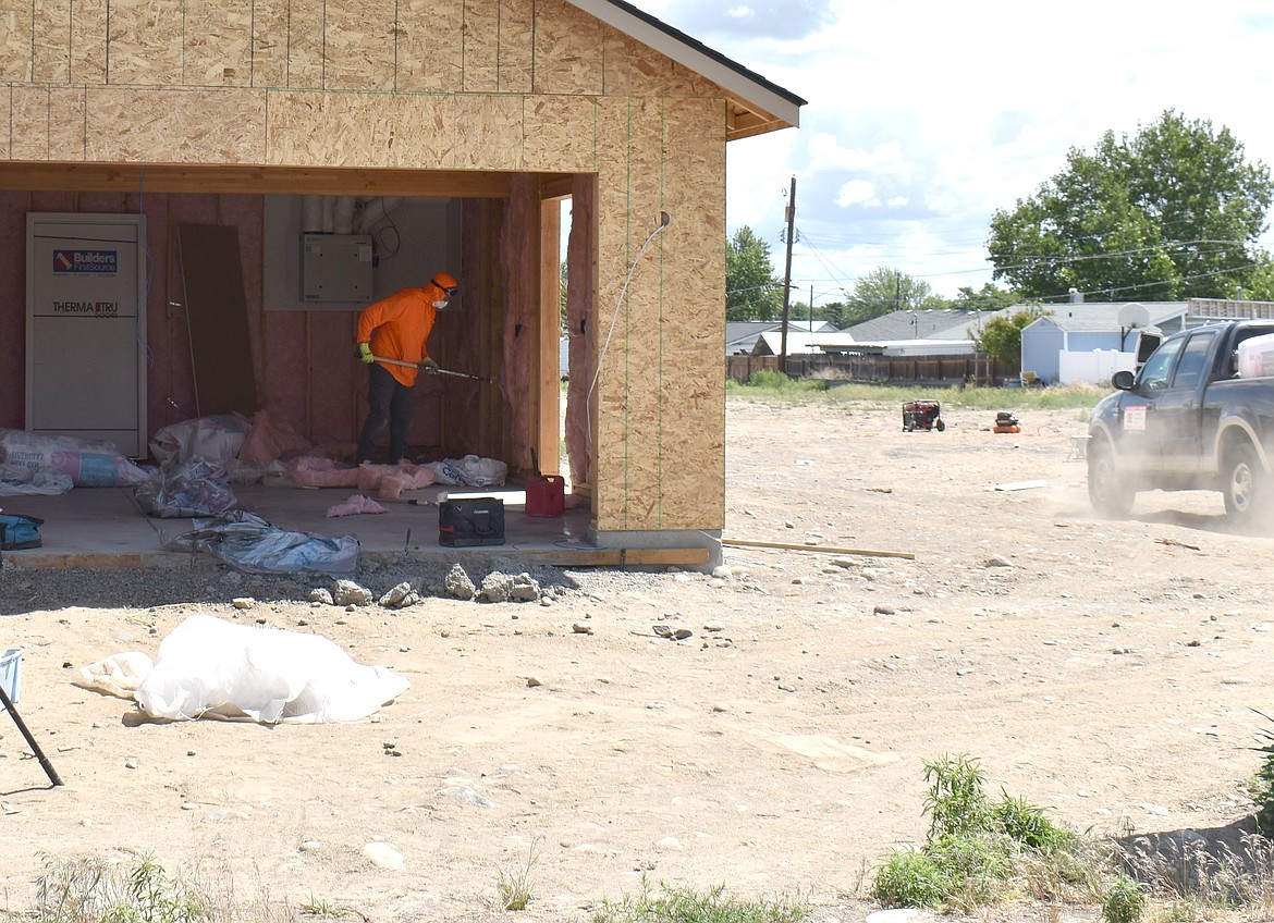 A worker installs insulation in one of the two Place at Knolls Vista homes that are under construction. There will be a total of 31 homes when the project is completed.