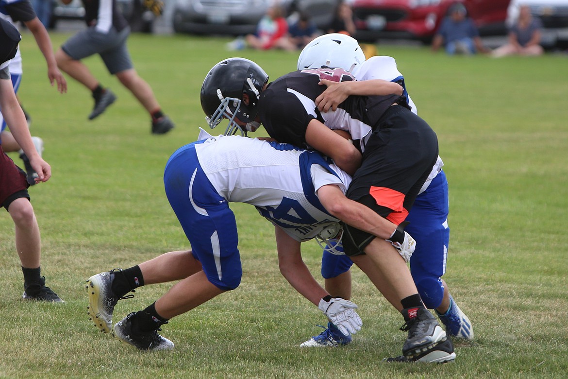 A pair of Soap Lake defenders tackle an ACH ball carrier at Friday’s jamboree in Coulee City.