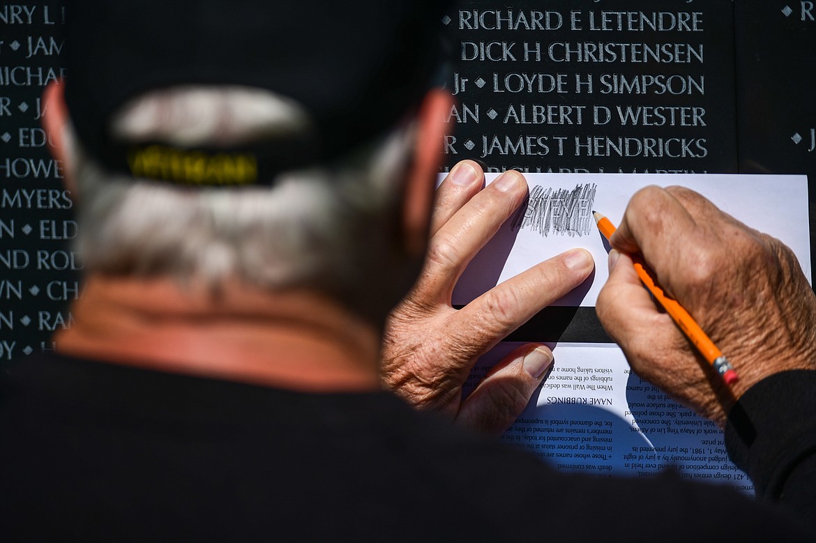 John Vollertsen, a Vietnam veteran from Helena, makes a rubbing of one of his two friends who were killed in action while serving together in the 101st Airborne Division of the U.S. Army on The Wall That Heals on Thursday, June 22.. They are Sgt. E5 Steven Perry and Spc. E4 Arnold Sarna. (Casey Kreider/Daily Inter Lake)