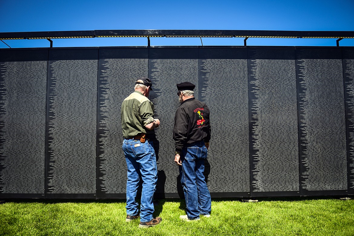Robert Wilson, right, a veteran of the Vietnam War and Desert Storm, helps John Feazelle, a fellow Vietnam veteran, locate names on The Wall That Heals on Thursday, June 22. (Casey Kreider/Daily Inter Lake)