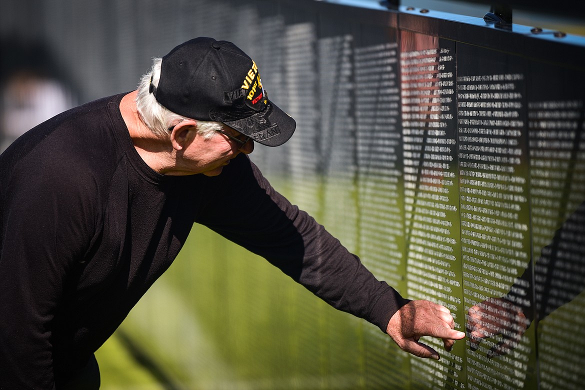 John Vollertsen, a Vietnam veteran from Helena, points to the name of one of his two friends who were killed in action while serving together in the 101st Airborne Division of the U.S. Army on The Wall That Heals on Thursday, June 22.. They are Sgt. E5 Steven Perry and Spc. E4 Arnold Sarna. (Casey Kreider/Daily Inter Lake)