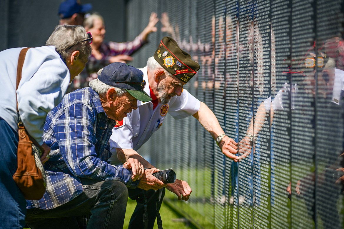 Mike Bennett, a Vietnam veteran and past state commander of Glacier Park V.F.W. Post 2252 in Kalispell, helps Martin Rippens and his wife, Annette Barclay Rippens, a Marine Corps. veteran, locate names on The Wall That Heals on Thursday, June 22. (Casey Kreider/Daily Inter Lake)