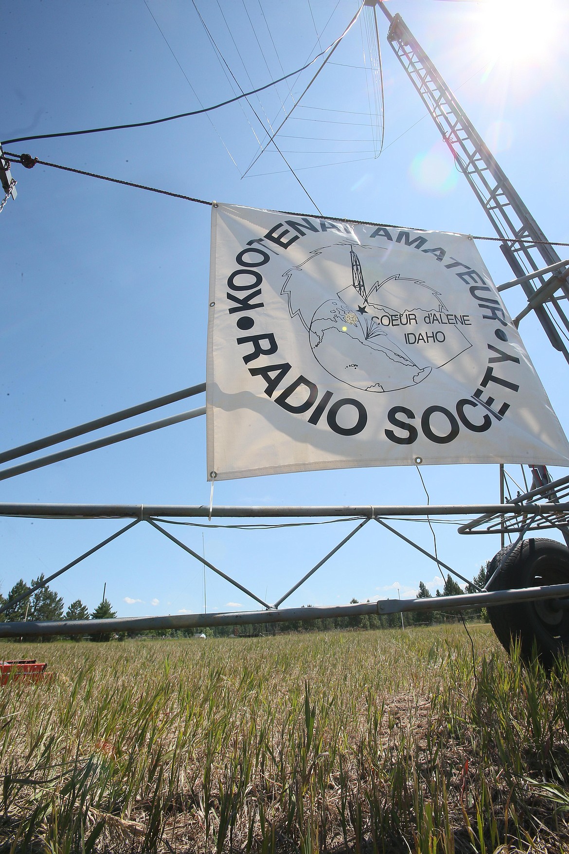 A Kootenai Amateur Radio Society banner hangs beneath a massive antenna Friday morning on Frank Krug's Post Falls property. Society members are participating in an Amateur Radio Field Day exercise today and Sunday.