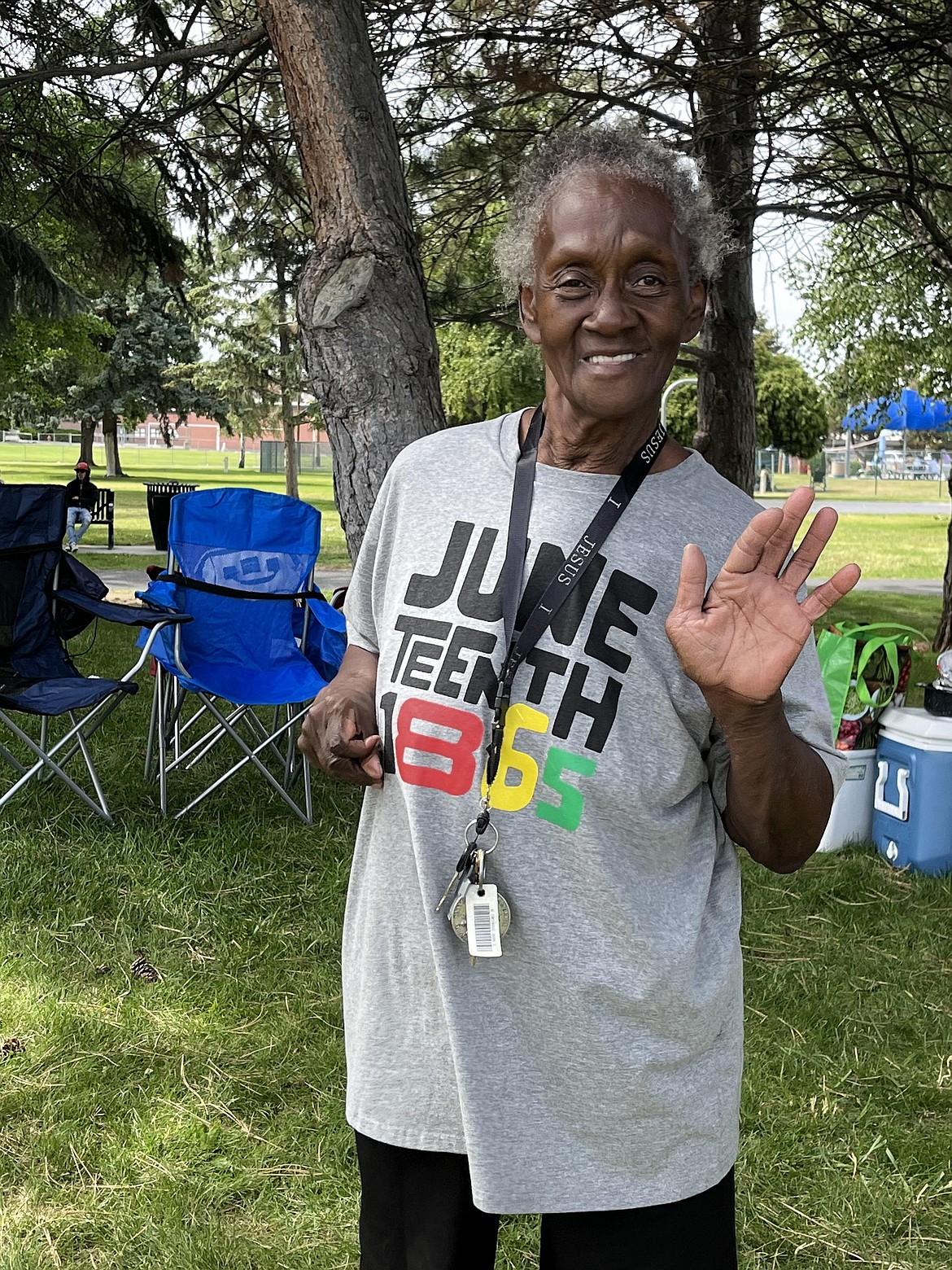 A member of the Moses Lake MLK Committee waves at the camera and smiles during the Juneteenth festivities. She is wearing a shirt that says “Juneteenth 1865,” the anniversary of the official end of slavery in Texas, the last state to be fully informed of the Confederacy and freedom for slaves there.