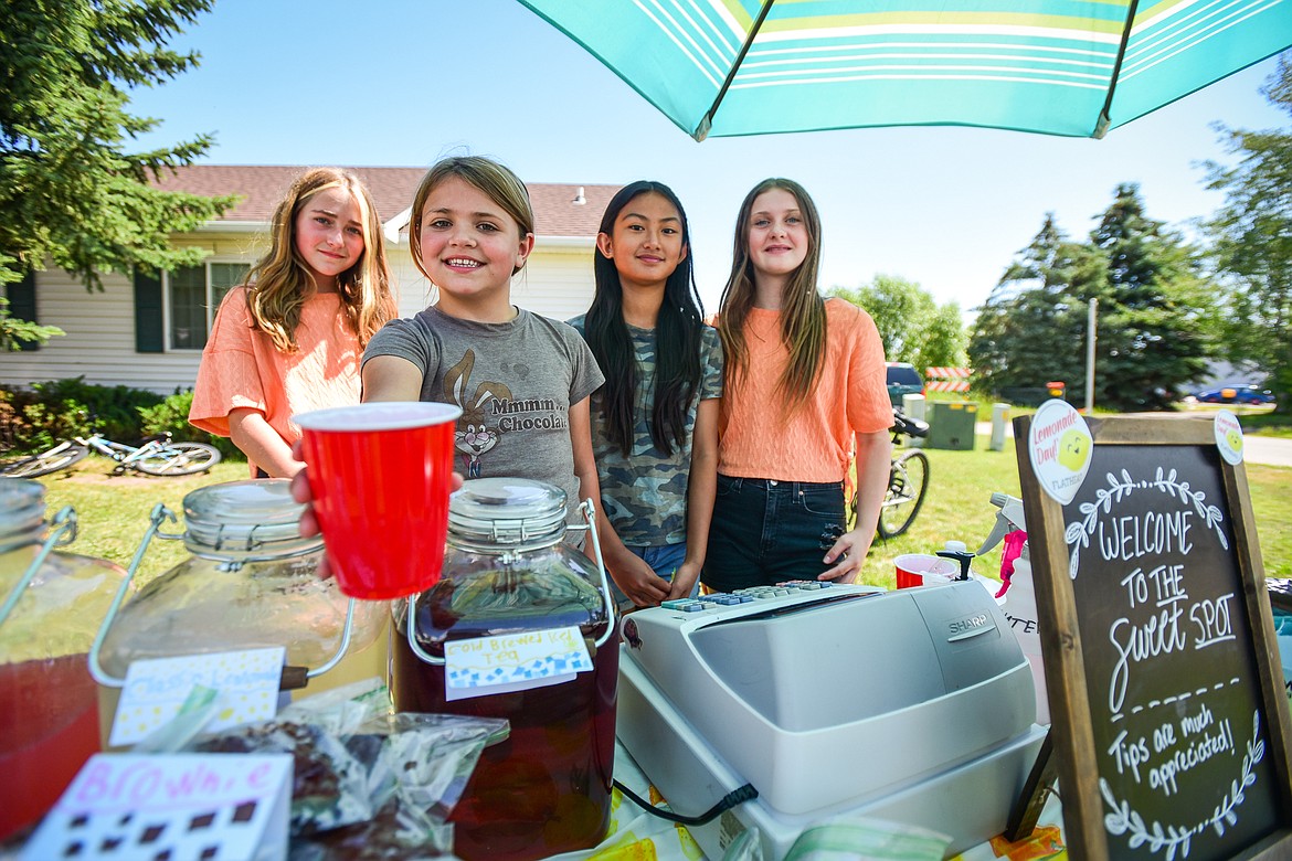 From left, Adelyn McCracken, Isabella Flores, Fiorenza Seniel and Sophia Harding operate The Sweet Spot stand serving freshly-squeezed classic and watermelon lemonade, cold-brewed ice tea, popsicles, cookies, muffins and brownies as part of the Lemonade Day program on Saturday, June 24. (Casey Kreider/Daily Inter Lake)