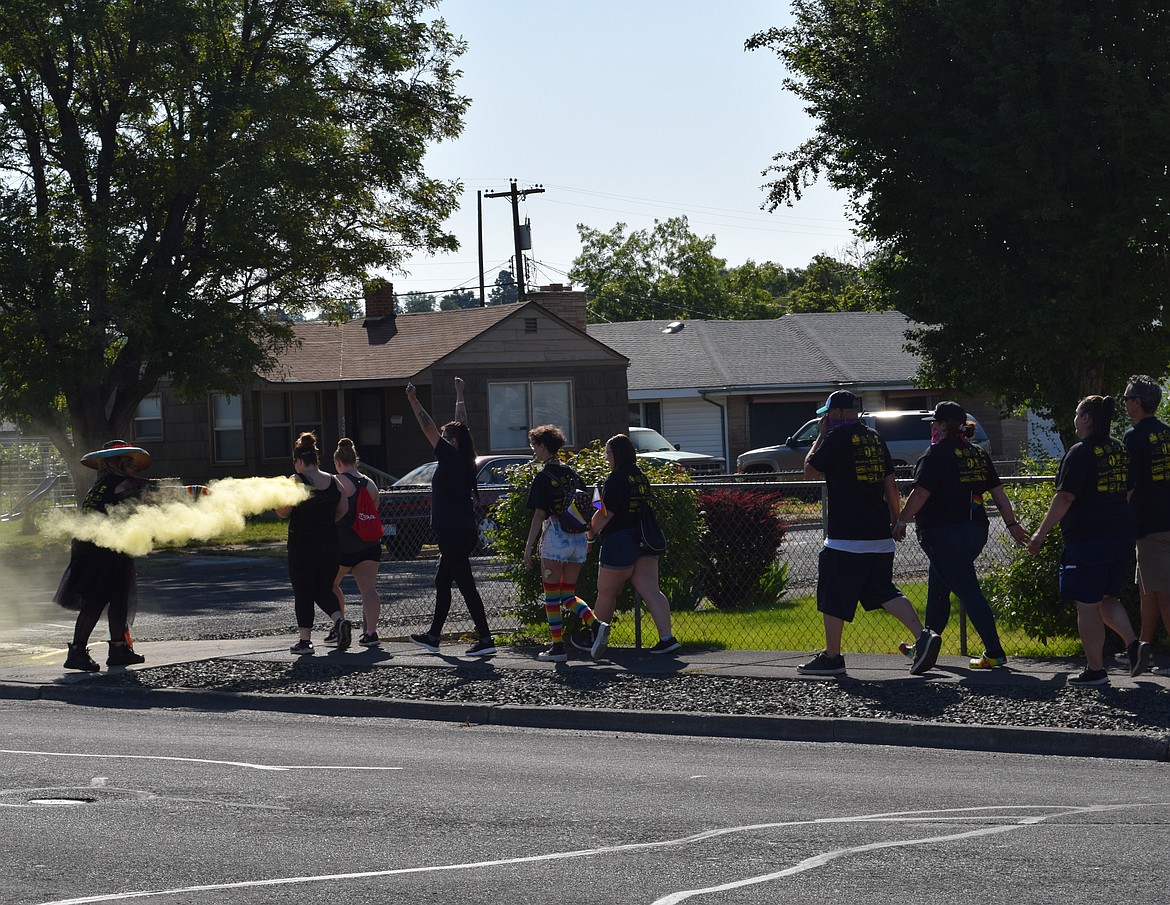 Participants receive their first batch of colored powder along Fifth Avenue, from a member of the first sponsor station along the path.