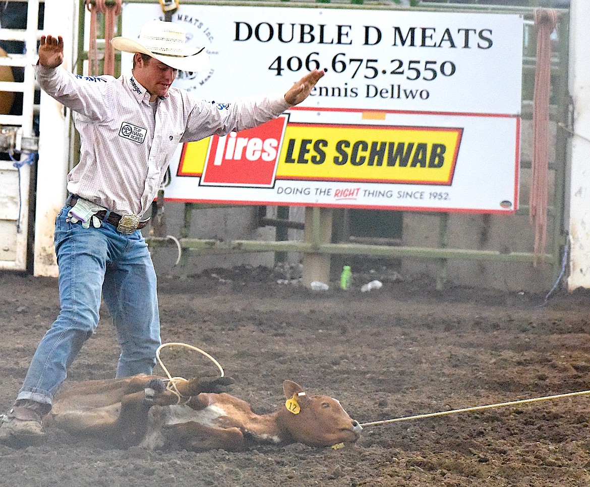 Throwing his hands i the air, this calf roper signals the flagger that his calf is tied. (Berl Tiskus/Leader)