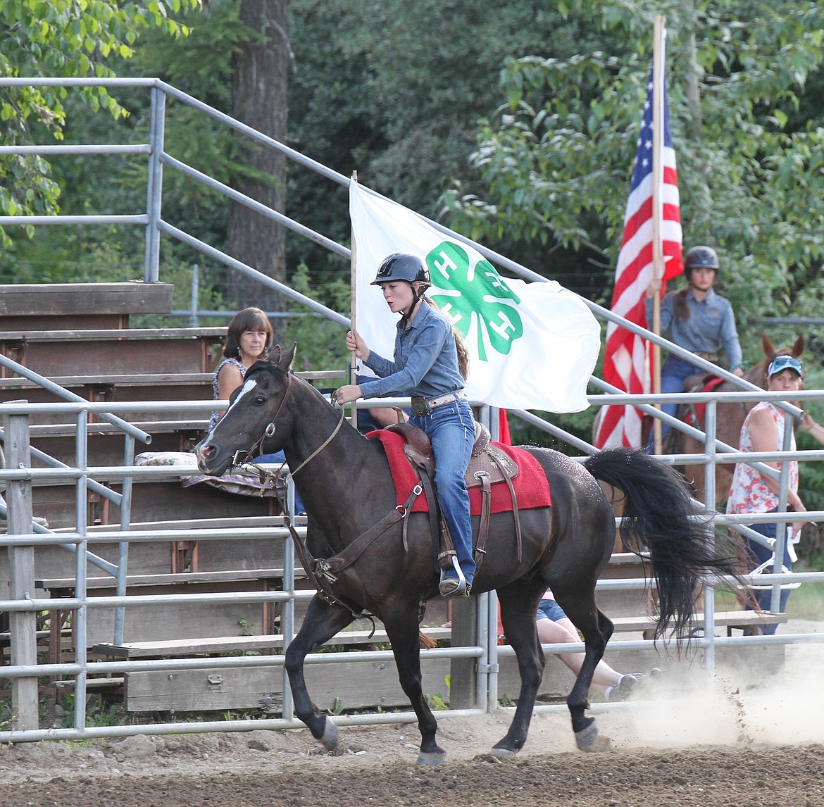 A rider carries the 4-H flag during the opening ceremony of the equestrian event on Friday.