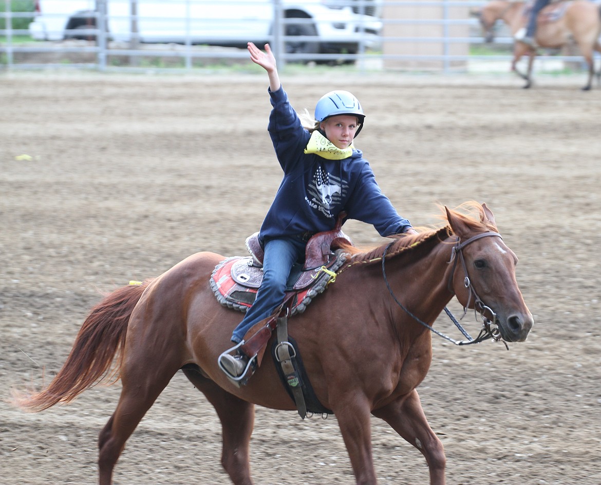 A rider waves to the crowd as she does a lap inside the stadium after her performance.