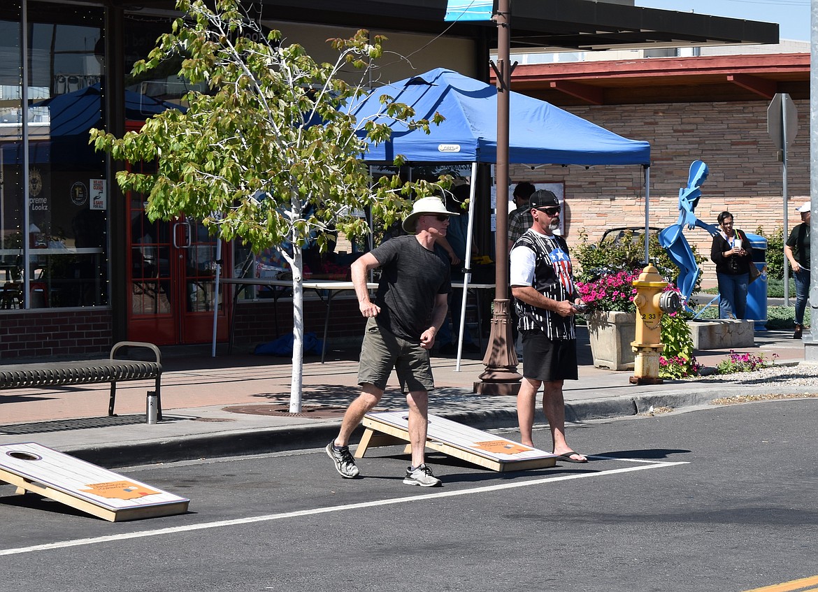 Cornhole competitors toss bean bags Saturday at the Downtown Moses Lake Association’s 30th birthday celebration. The event drew shoppers downtown, one of the DMLA’s primary goals.