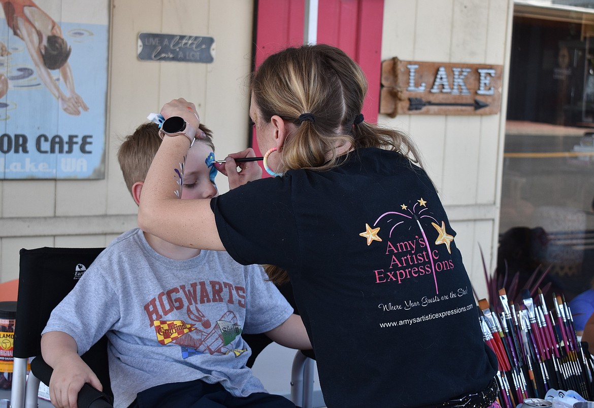 A face painter from Amy’s Artistic Expressions puts artwork on the face of William Zuver, who was out enjoying the event with his family.