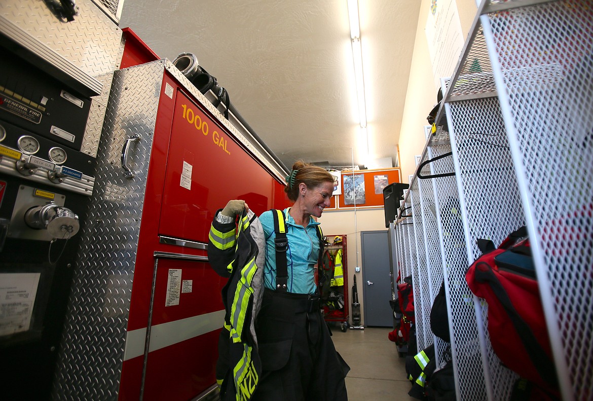 Firefighter and EMT Birgid Niedenzu gears up Tuesday at the East Side Fire District's Arrow Point Station in Harrison. About one third of the volunteer department and about three quarters of its emergency response team are women.