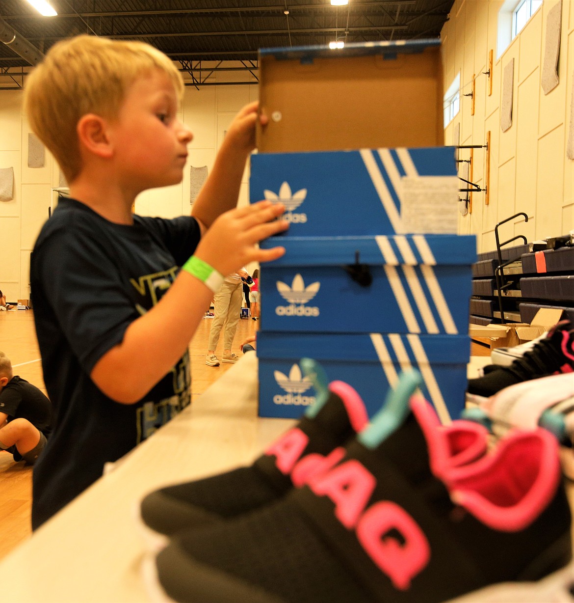 Beckham Pleas looks at a box to check out a pair of shoes at the Lola and Duane Hagadone Boys and Girls Club on Tuesday.