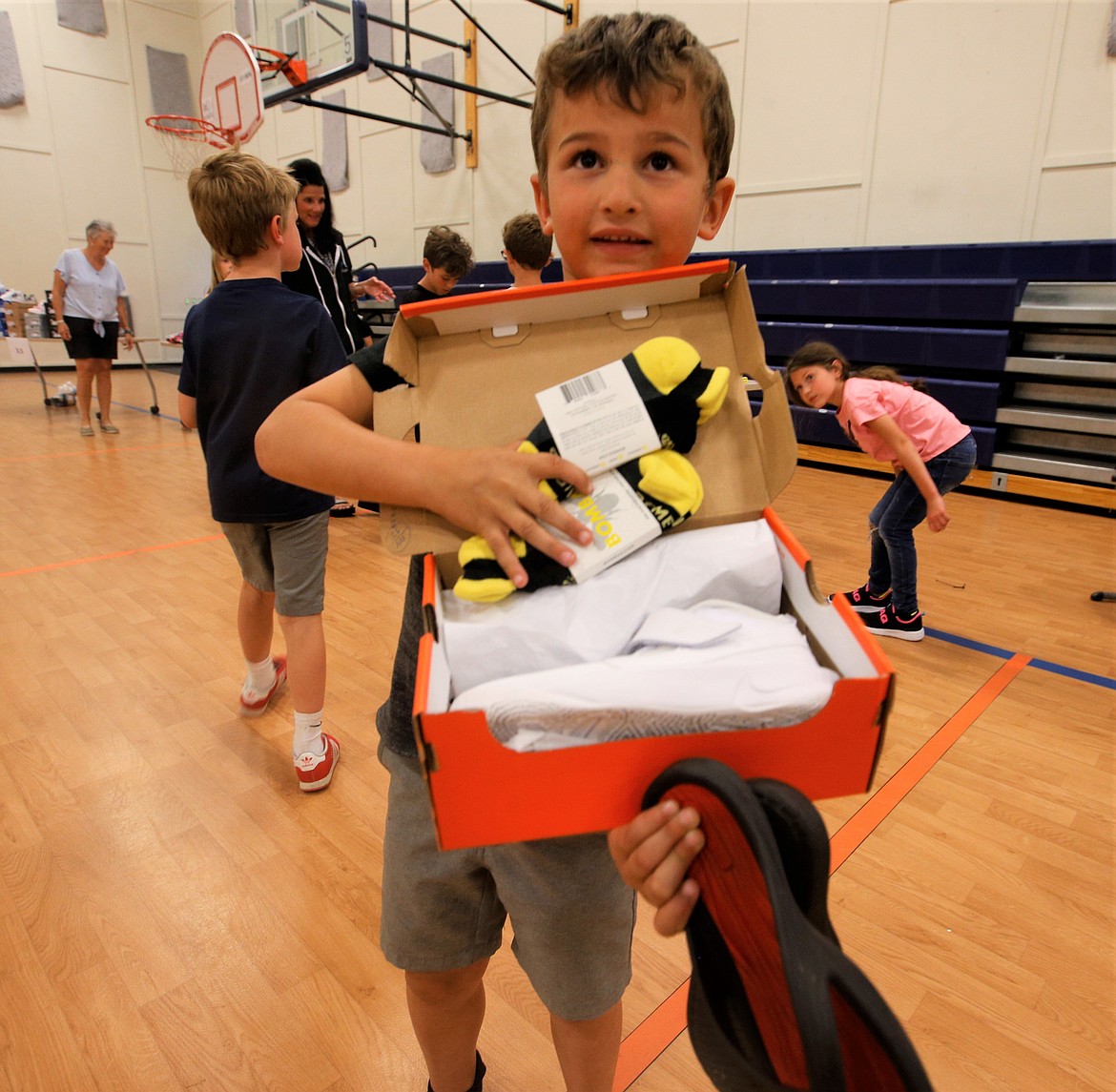 Owen Swaim opens a box to reveal his new Nike shoes he received Tuesday at the Lola and Duane Hagadone Boys and Girls Club of Kootenai County.