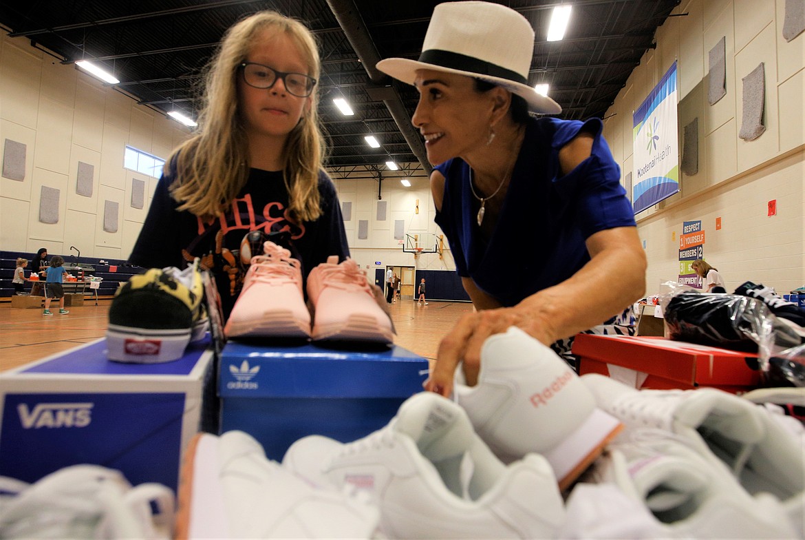 Rita Case helps a girl look for a pair of shoes at the Lola and Duane Hagadone Boys and Girls Club on Tuesday.