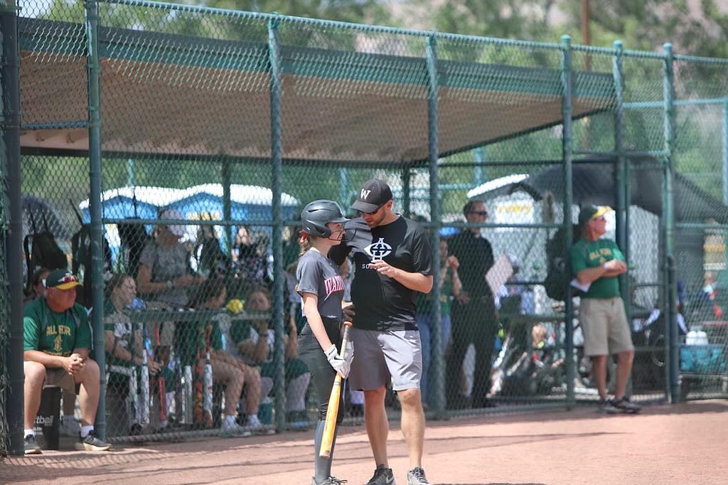 ACH softball Head Coach Graham Grindy, right, talks with a player during a softball game. Grindy became head coach of the Warriors in 2017, winning back-to-back titles in 2018 and 2019.