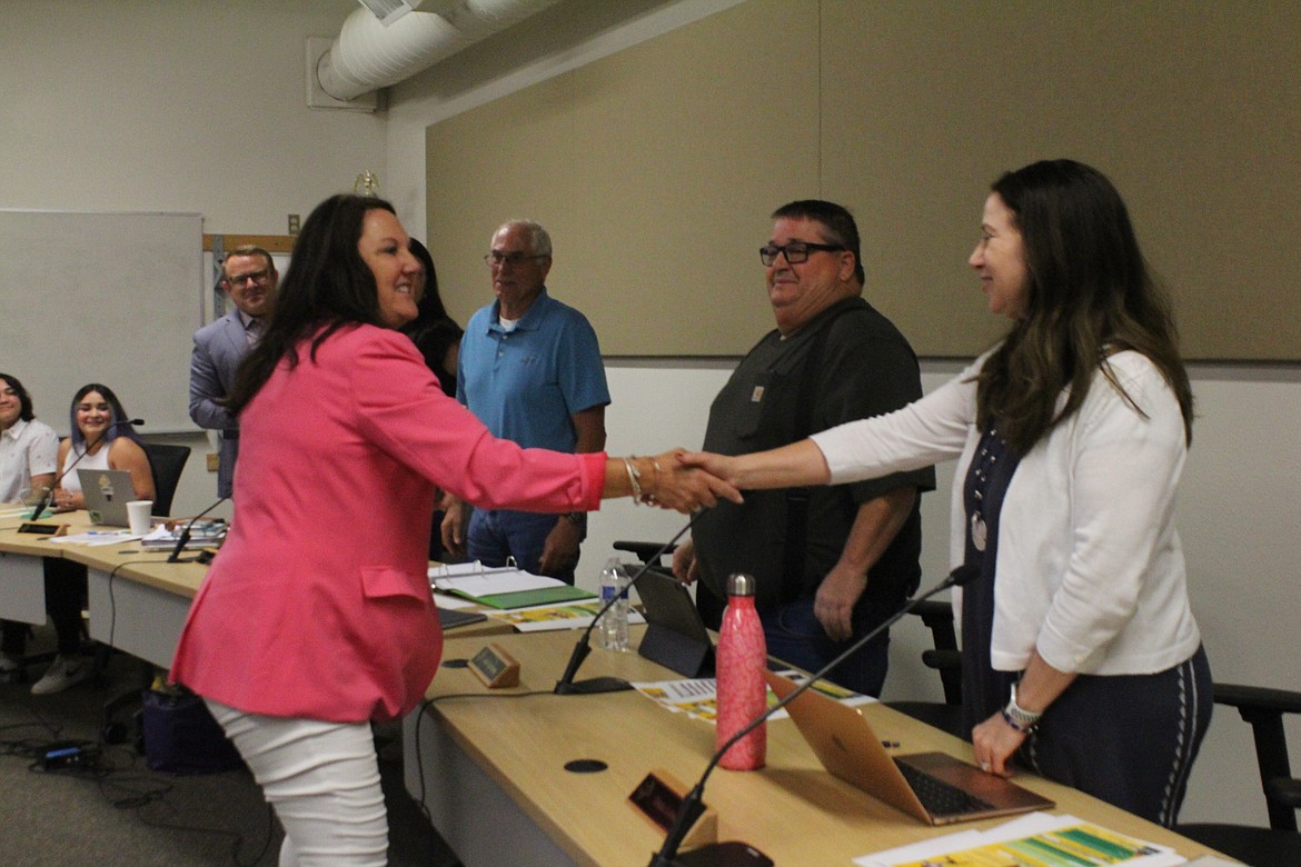 North Central ESD Superintendent Michelle Price, left, shakes hands with Quincy School Board member Tricia Lubach, right, after Price presented the ESD School Board of the Year award at the board meeting Tuesday.