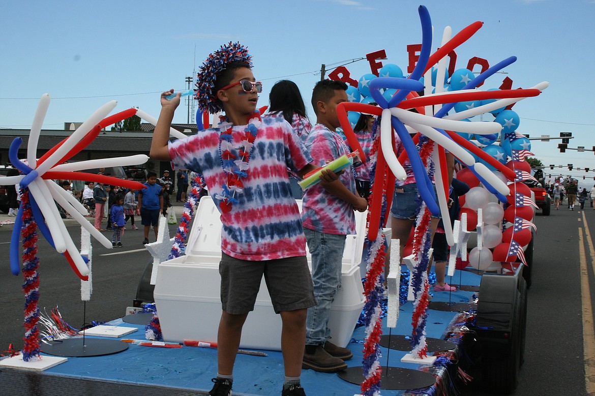 A participant prepares to throw an ice pop at the 2022 July 4 parade in Othello. The nation’s birthday will be celebrated with parades, pie and fireworks in Columbia Basin communities.