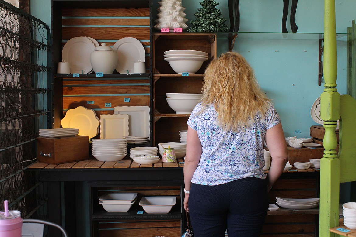 A customer looks at wares in a pottery shop. While customers have a number of options, they’re returning to in-person shopping, according to the Washington Retail Association.