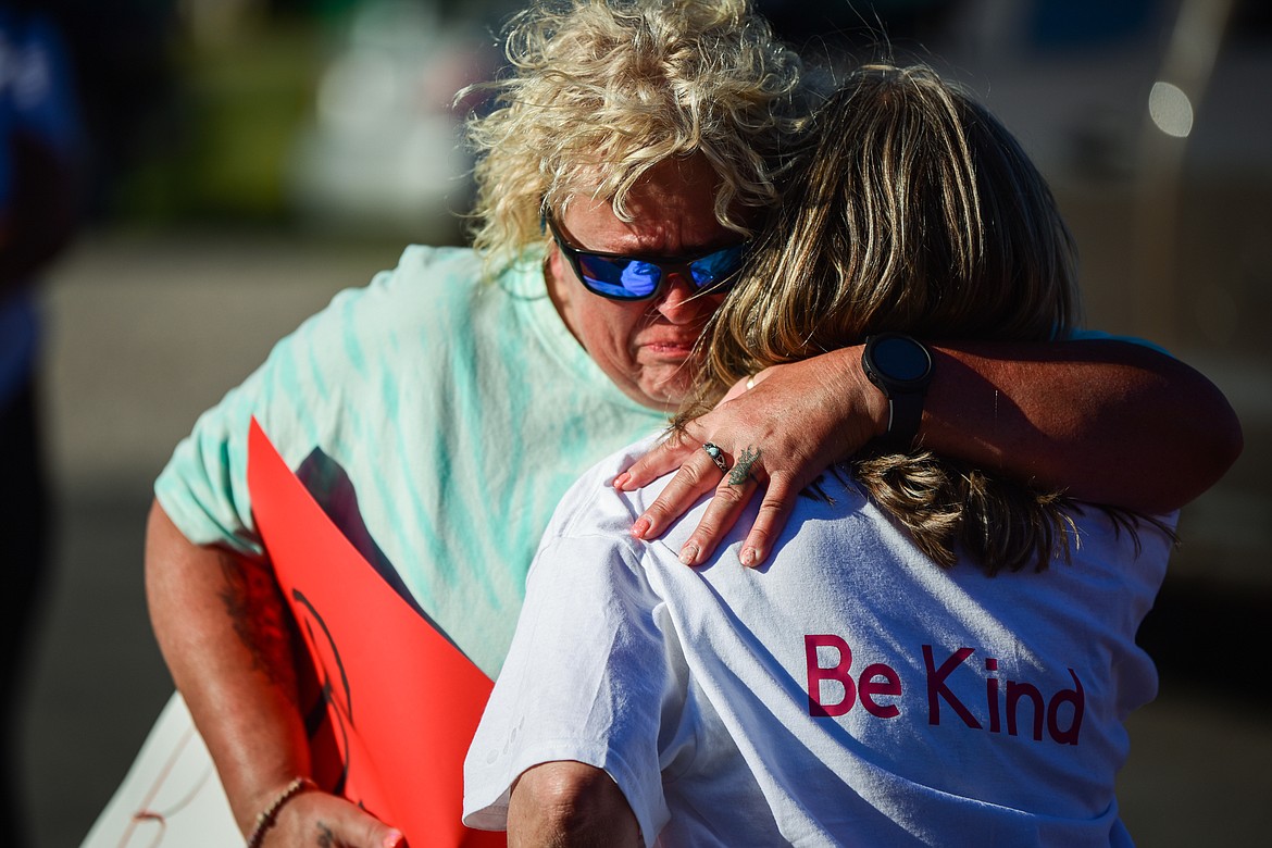 Debbie Profitt, left, and Kari Galassi, friends of Scott Bryan, embrace during a vigil and walk to The Warming Center in Kalispell on Saturday, July 1. Kaleb Elijah Fleck, 19, is accused of beating Bryan, a homeless man, to death outside a Kalispell gas station on the morning of June 25. (Casey Kreider/Daily Inter Lake)