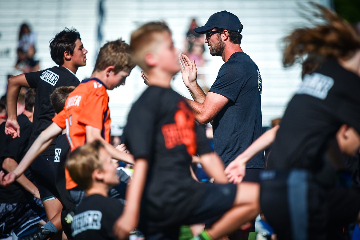 Campers get warmed up during a pair of free football camps held by former NFL and Flathead Braves quarterback Brock Osweiler at Legends Stadium in Kalispell on Saturday, July 1. (Casey Kreider/Daily Inter Lake)