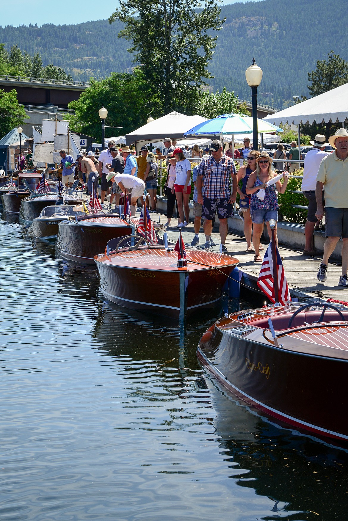 People walk along the Sandpoint Boardwalk as they enjoy the classic wooden boats at a past Sandpoint Boat Show.
