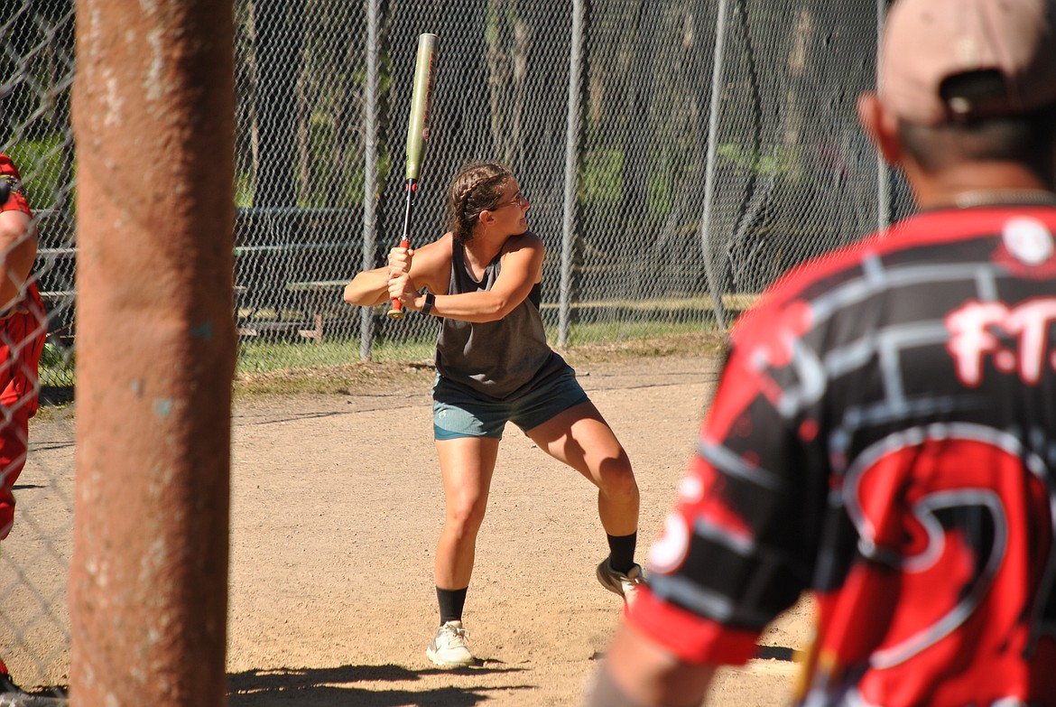 A batter takes a strong step into her swing and safely makes it to first base on Saturday during the annual St. Regis Liberty Bash Softball Tournament. 12 men's teams and 12 co-ed teams from all around Idaho, Washington, and Montana, compete from Friday to Sunday and winners take home prizes and bragging rights. (Amy Quinlivan/Mineral Independent)