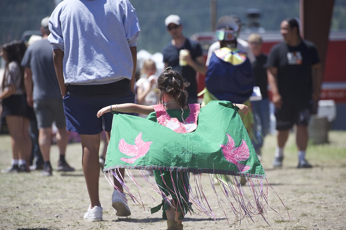 A little girl spreads her shawl, decorated with two pink birds, in the summer breeze while wandering between the food stalls at the Arlee Celebration. (Max Dupras/Leader)