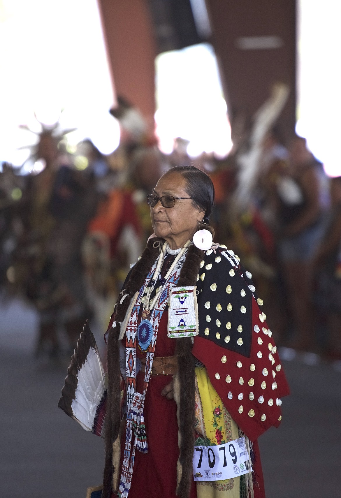 A woman dressed with long fur hair ties and regalia patterned with shells dances during Saturday's grand entry at the Arlee Celebration. (Max Dupras/Leader)