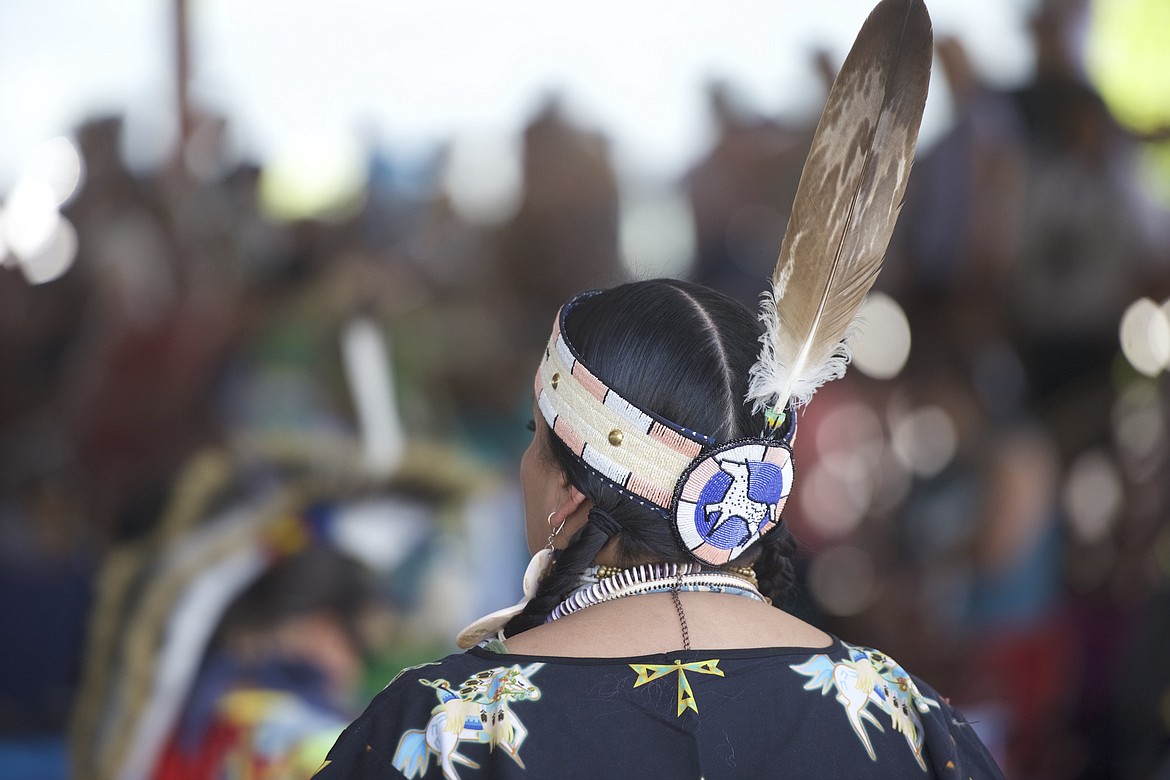 A woman watches the dancers during grand entry at the annual Arlee Celebration. (Max Dupras/Leader)