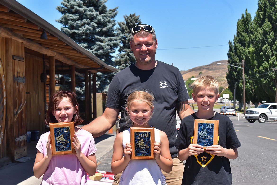 Soap Lake Police Department Chief Ryan Cox, back, poses with the winners of the Soap Box races. From left to right in the front, Langstyn Rhoads, 9, Rayginn Baughman, 9, and Eli Leenhouts, 11.