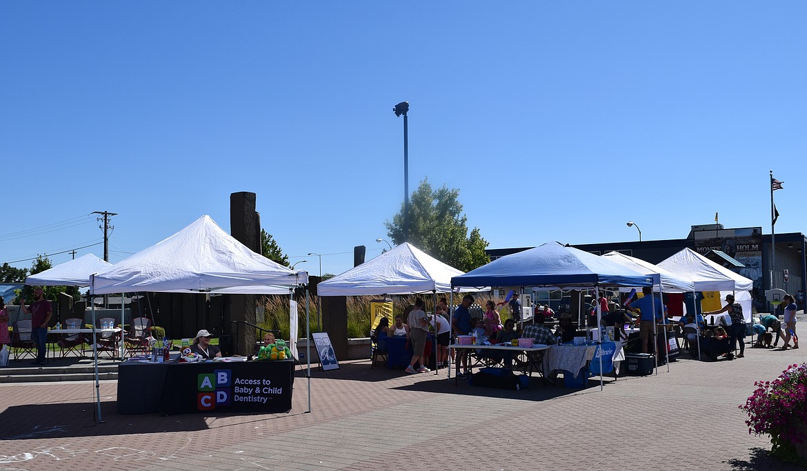 Various booths in Sinkiuse Square during Red, White & Boom’s Party on Third Avenue provide information on local and regional organizations and the activities and services they offer.