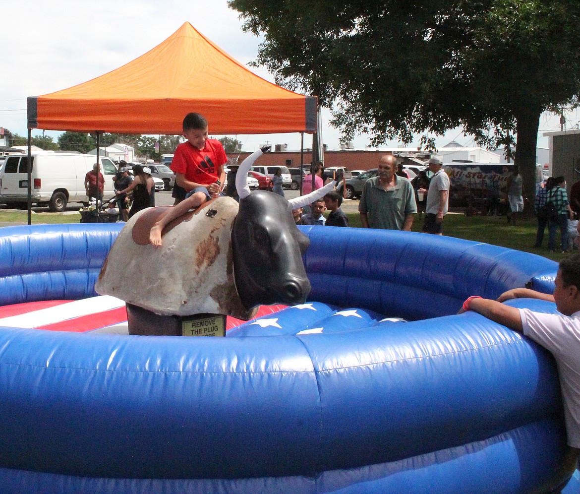 A young buckaroo tries to keep his seat on the mechanical bull at last year’s Summerfest. This year’s event is Friday and Saturday.