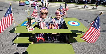 Brothers Cooper Leary, left, and Dawson Leary, in their "American Pilot" motorized car. display their first-place trophy following the annual Kiddies Parade sponsored by the Coeur d’Alene Recreation Department on Monday.