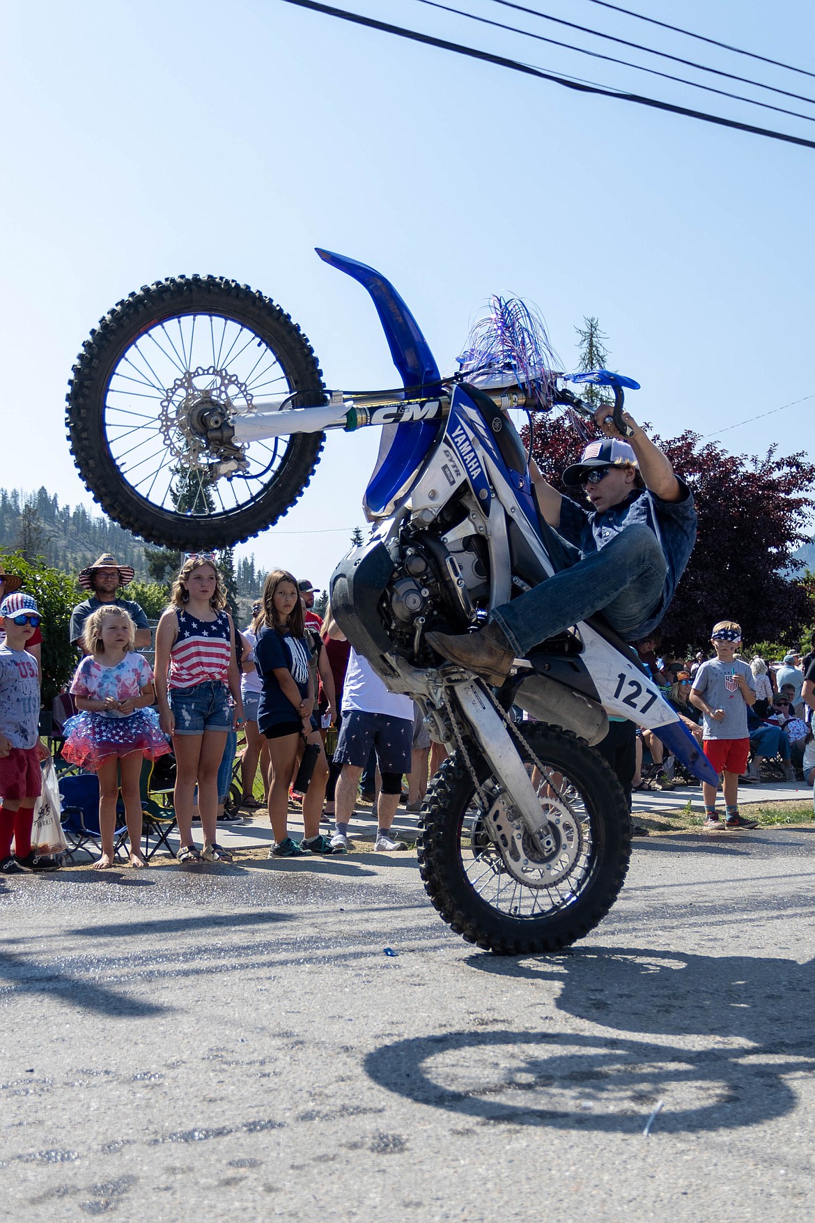 A motorcycle rider pops a wheelie during the Clark Fork Fourth of July parade on Tuesday.