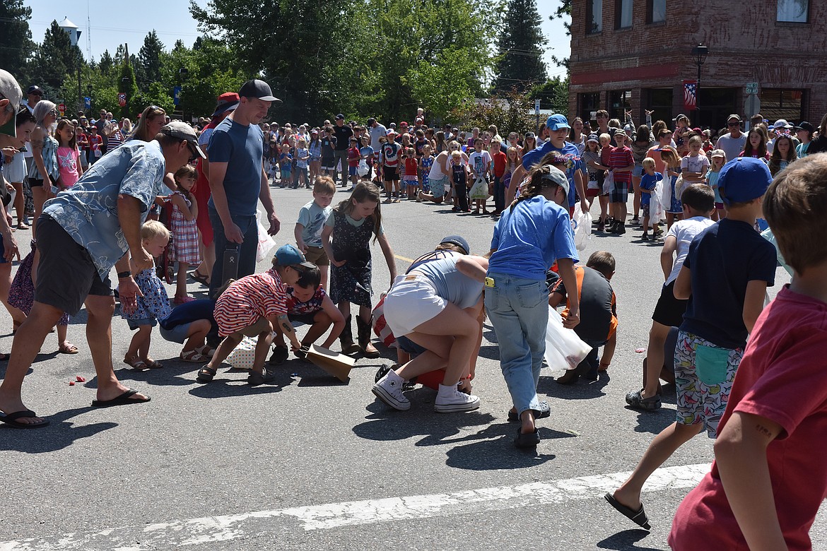 Children make a mad dash to pick up candy thrown by a Spirit Lake parade unit.