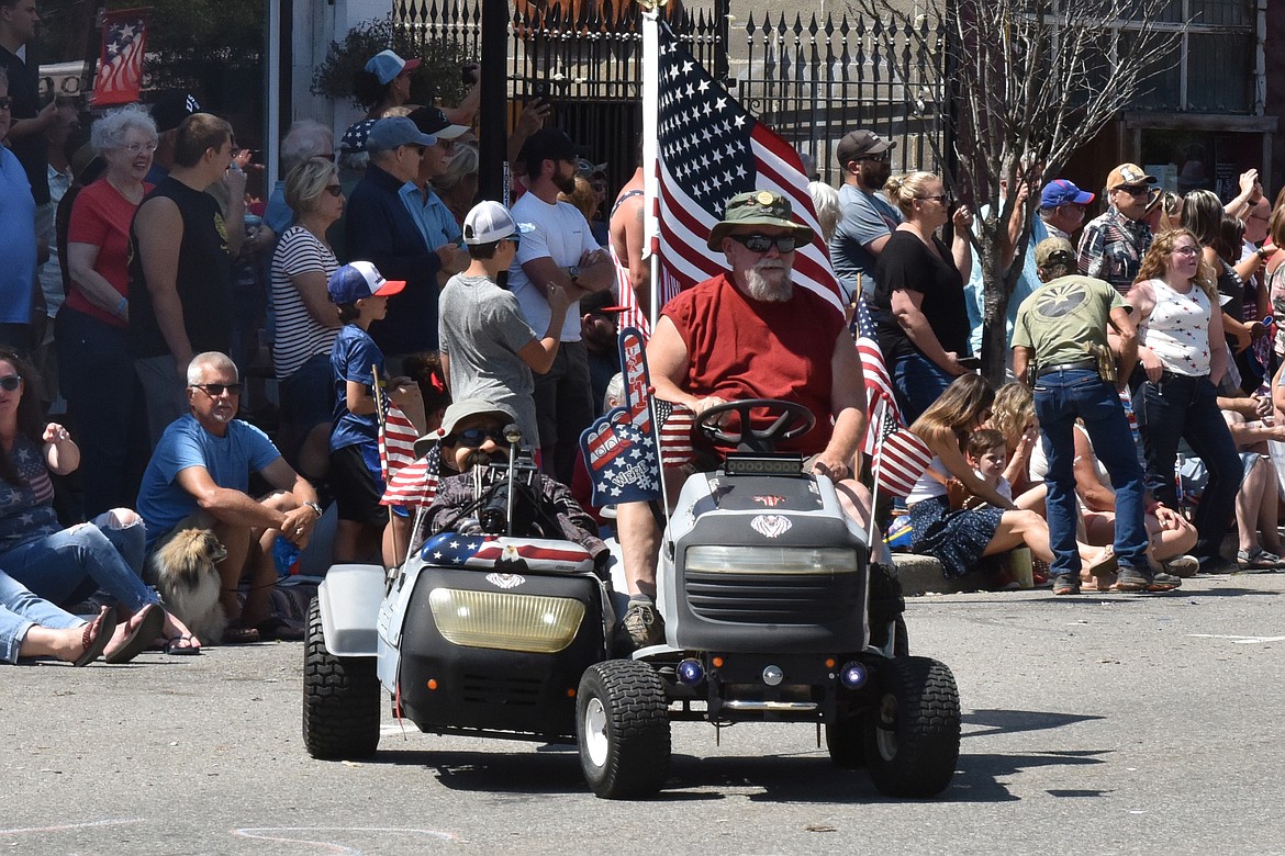 A sidecar lawnmower moves along with the Spirit Lake Fourth of July parade.