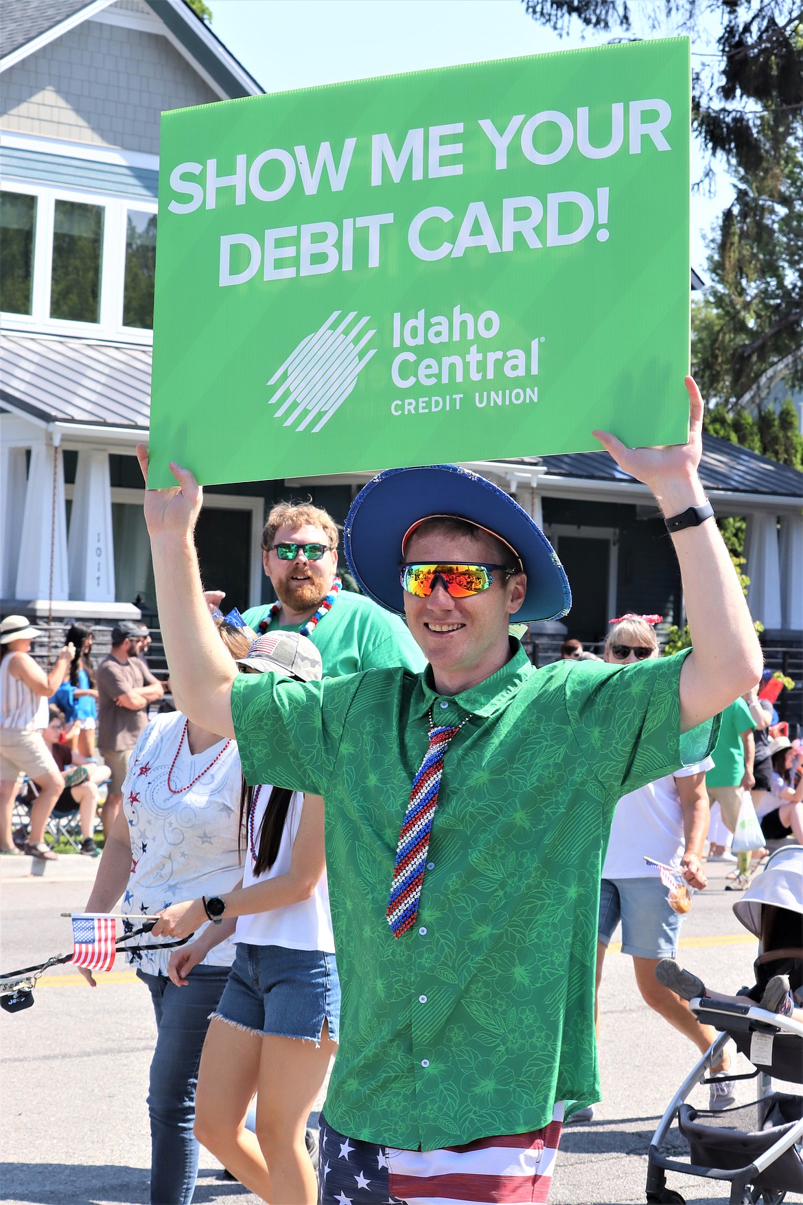 Kyle Honaker holds a sign with Idaho Central Credit Union during the Fourth of July parade on Tuesday.