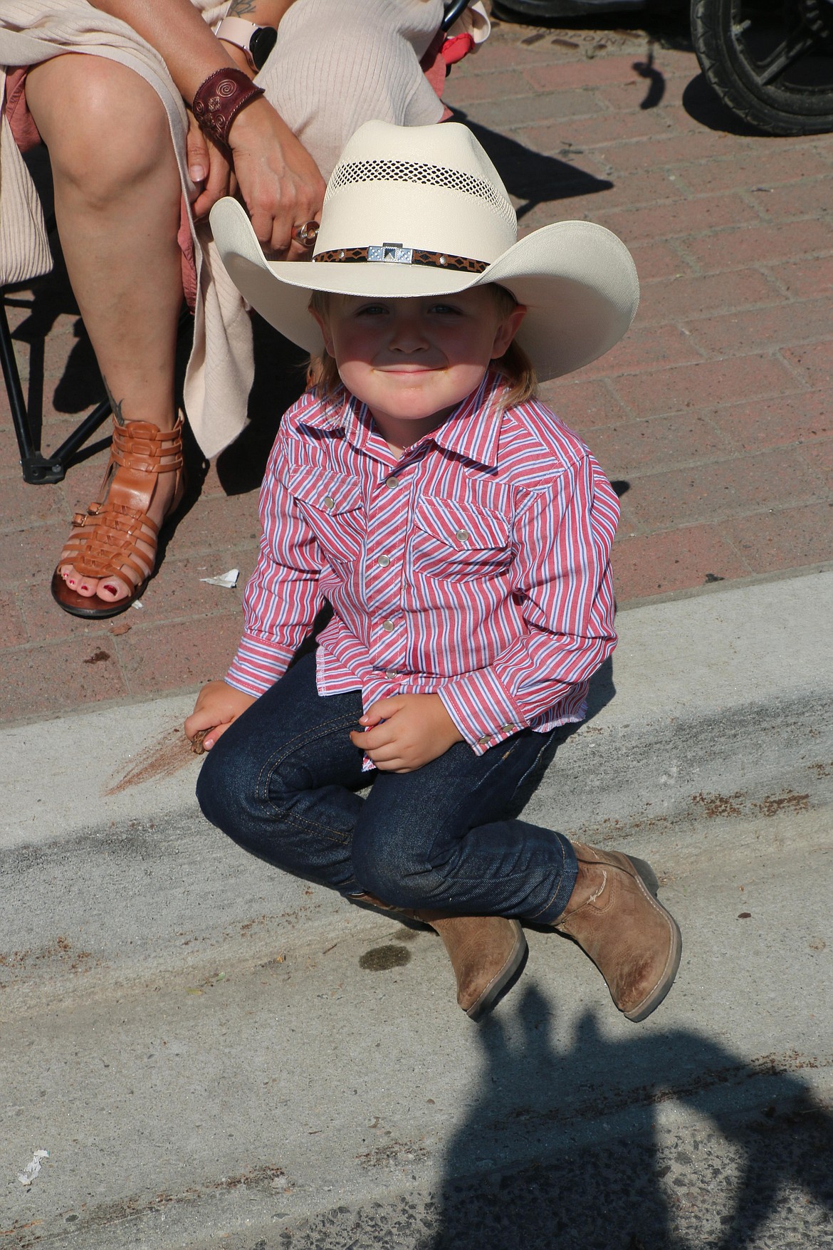 A youngster watches the Sandpoint Lions grand parade on Tuesday from beneath his cowboy hat.